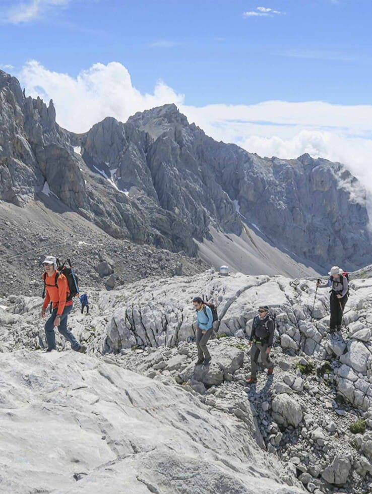 un grupo de personas federados en la federacion madrileña de montañismo realizando la actividad de senderismo en la pedriza como deporte de montaña en madrid