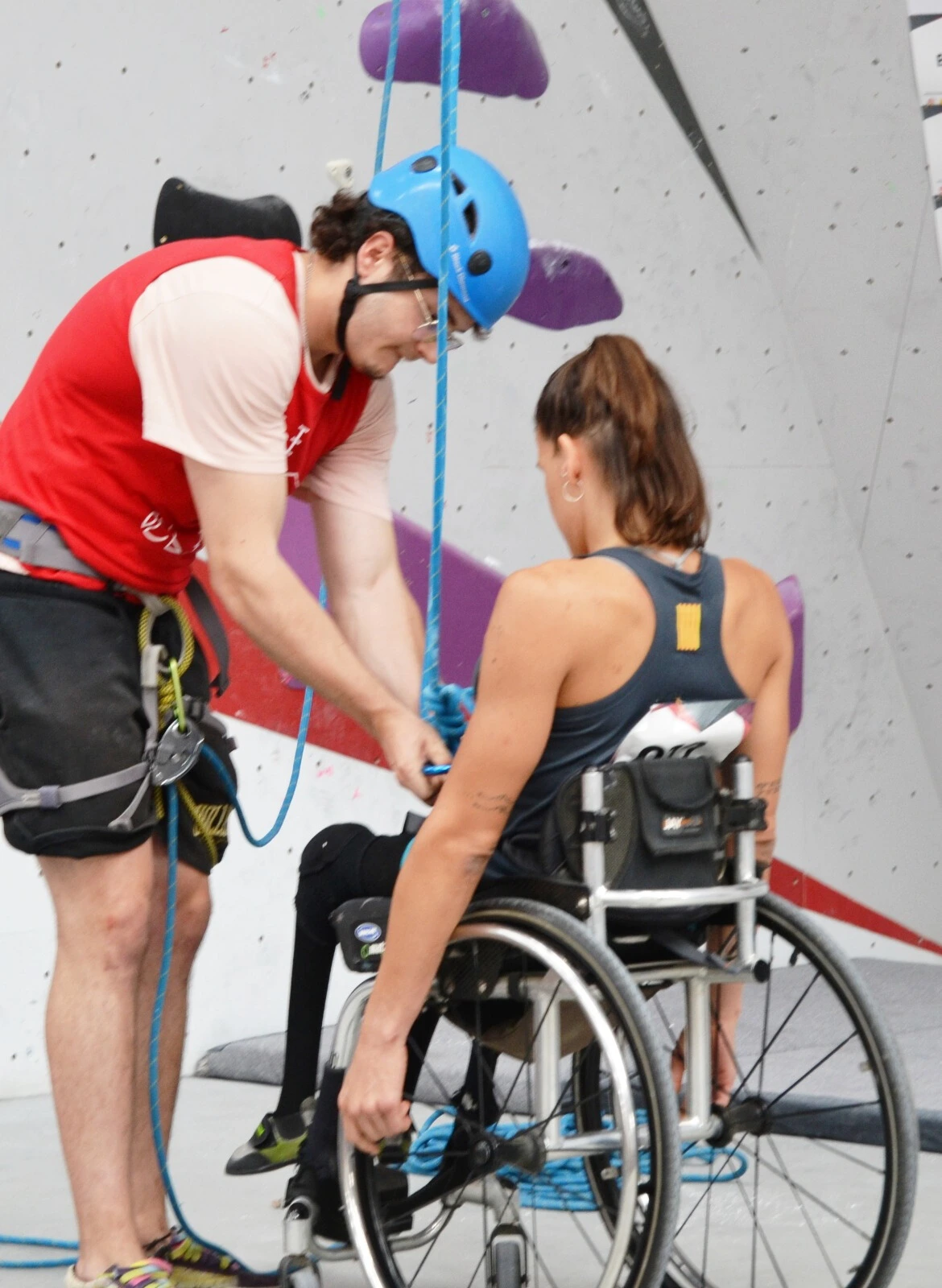 una mujer con discapacidad motriz y su ayudante para que realice escalada como deporte inclusivo